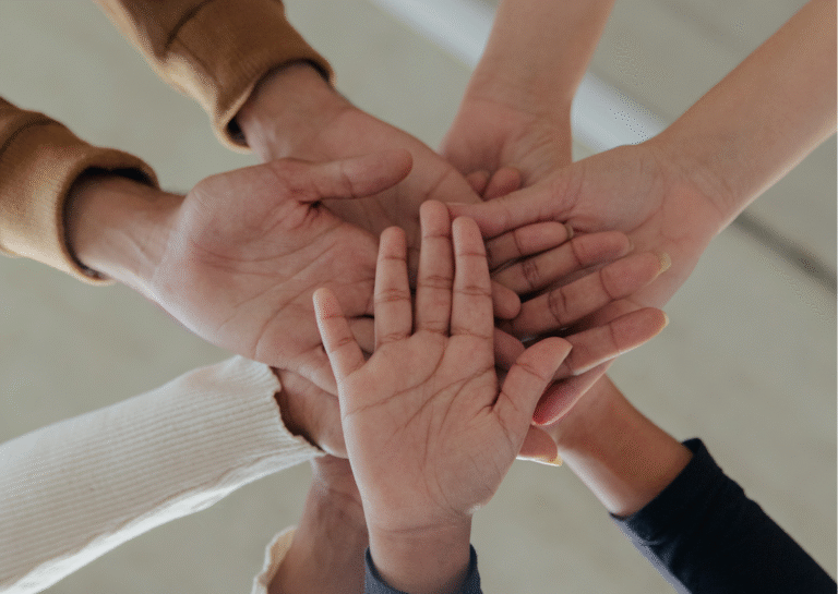 7 manos entrelazándose juntas